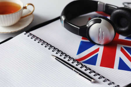 Learning foreign languages. Notepad for entries and a flag. Language courses, audio audition.の写真素材