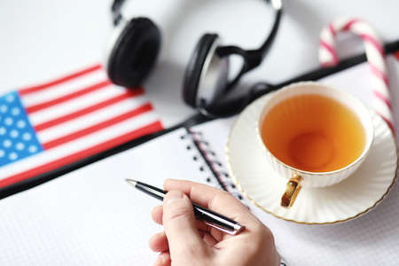 Learning foreign languages. Notepad for entries and a flag. Language courses, audio audition.の写真素材