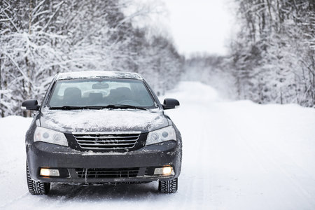 the car stands on a snow-covered road in a wintertime cloudy day