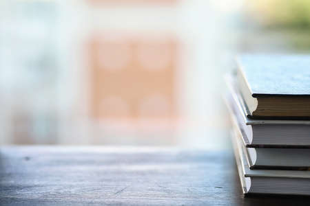 A stack of textbooks on the windowsillの写真素材