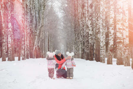Children walk in the park in winter. Winter forest a family withの写真素材