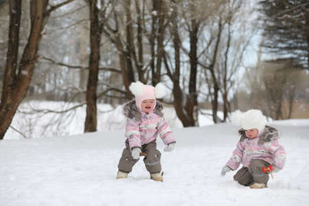 Children walk in the park in winter. Winter forest a family withの写真素材
