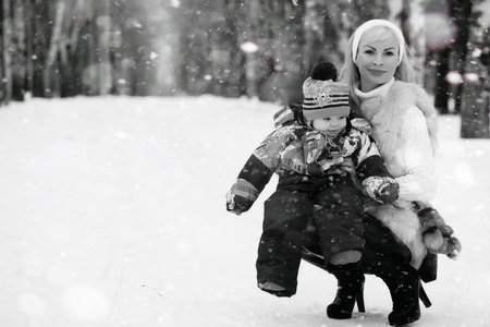 A young mother walks on a winter day with a baby in her armsの写真素材