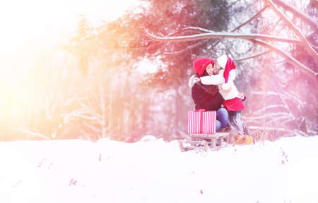 A winter fairy tale, a young mother and her daughter ride a sledの写真素材