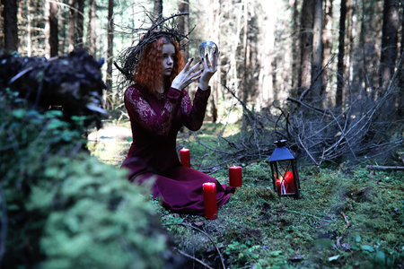 The red-haired witch holds a ritual with a crystal ball