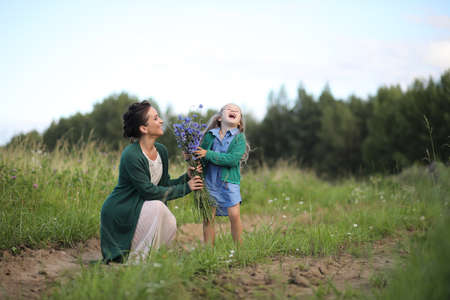 Mother with daughter walking on a roadの写真素材