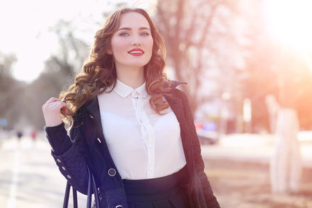 Girl business woman in the spring on a walk in a coatの写真素材