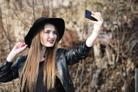 Young beautiful girl in a hat and with a dark make-up outside.の写真素材