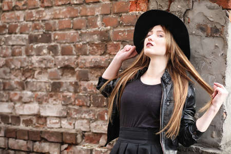 Young beautiful girl in a hat and with a dark make-up outside.の写真素材