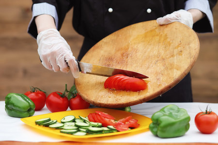 The cook cuts fresh farm vegetablesの写真素材