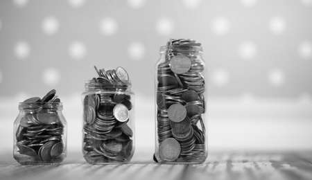 Coins in a jar on the floor. Accumulated coins on the floor. Pocket savings in piles.
の写真素材