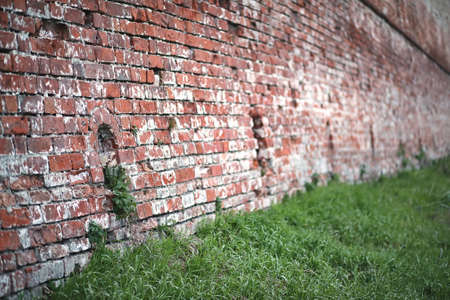 Old red brick wall with a crack and traces of paint

の写真素材