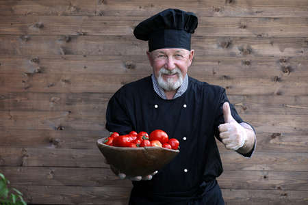 Chef old in uniform with fresh vegetablesの写真素材