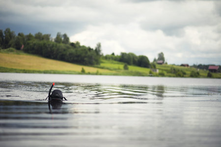 A scuba diver in a wet suit prepares to immerse in a pondの写真素材