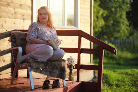 An elderly woman on the porch of a houseの写真素材
