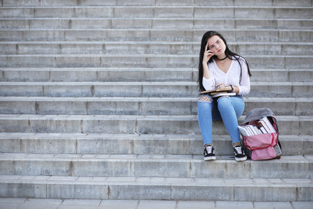 Girl student on the street with booksの写真素材