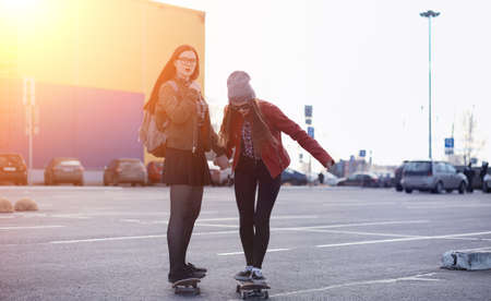 A young hipster girl is riding a skateboard. Girls girlfriends fの写真素材