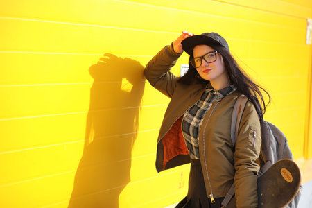 A young hipster girl is riding a skateboard. Girls girlfriends fの写真素材