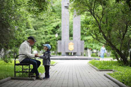 Grandpa is walking with her grandson in a spring park. Grandsonの写真素材