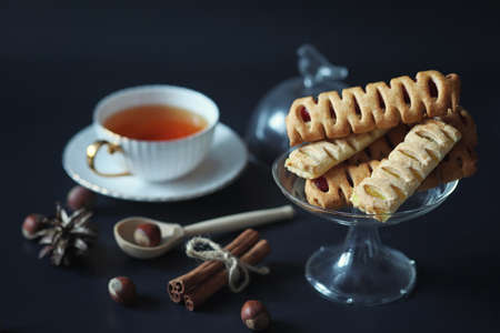 Set for breakfast. Sweets and pastries with nuts for tea on black background. A coffee cup and patties.
の写真素材