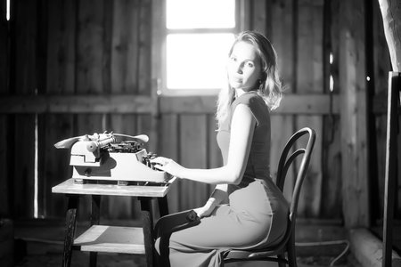 A girl typing with an old typewriter