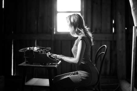 A girl typing with an old typewriterの写真素材
