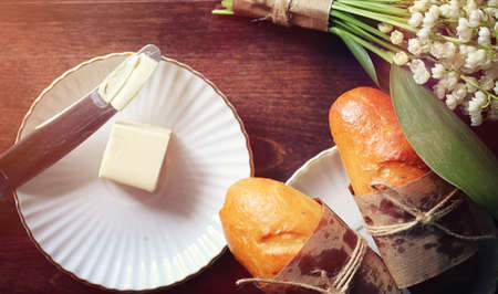 Fresh rolls for breakfast. Bun with butter to a cup of coffee inの写真素材