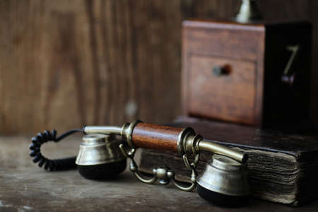 Old telephone and retro book on a woodの写真素材
