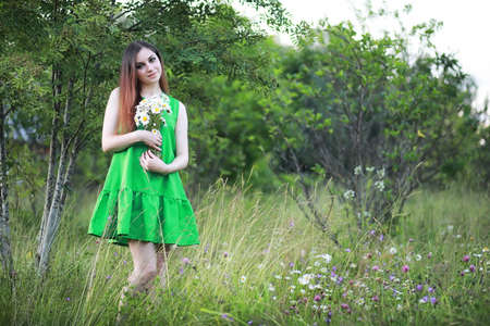 beautiful girl with red hair with a bouquetの写真素材