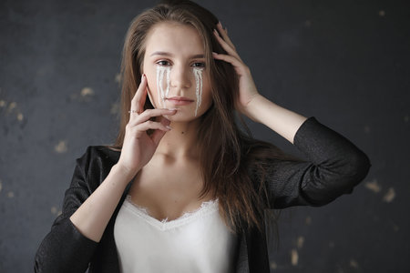 Beautiful girl with tears in her eyes. Young girl with painted t