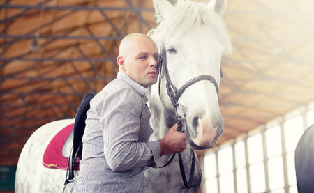People on a horse training in a wooden arenaの写真素材