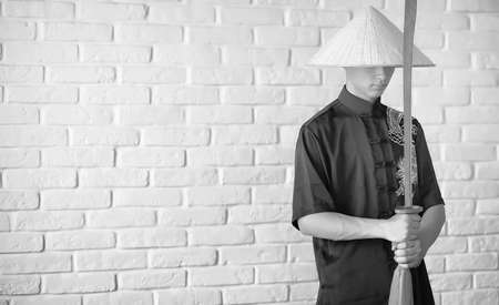 Asian novice on a white brick wallの写真素材