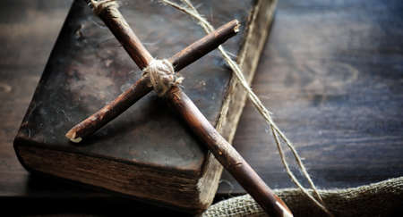 Religious old book on a wooden table. A religious cross tied witの写真素材
