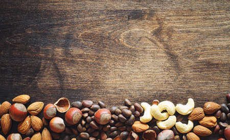 Different nuts on a wooden table. Cedar, cashew, hazelnut, walnuの写真素材