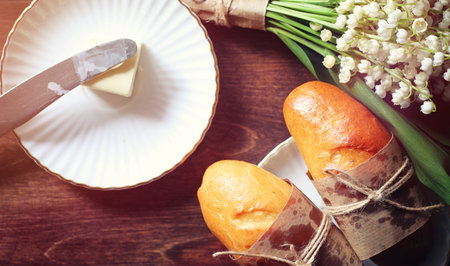 Fresh rolls for breakfast. Bun with butter to a cup of coffee inの写真素材