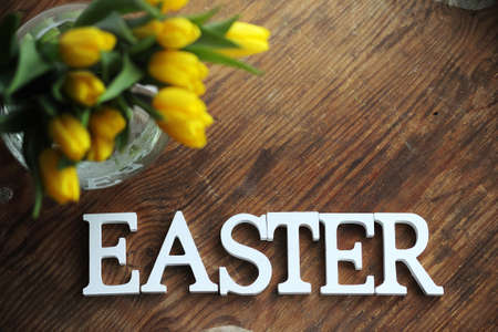 A bouquet of yellow tulips in a vase on the floor. A gift to a wの写真素材