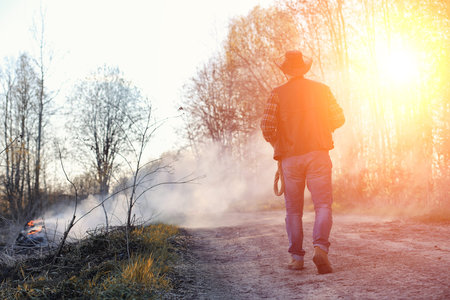 A man is wearing a cowboy hat and a loso in the field. Americanの写真素材