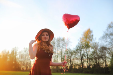 A girl in a hat on a walk in the park. A girl with a basket walkの写真素材