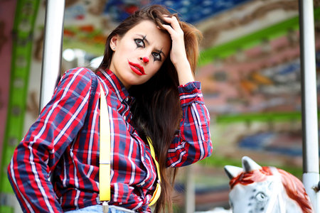 Cute girl in a clown makeupの写真素材