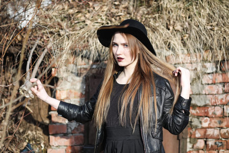 Young beautiful girl in a hat and with a dark make-up outside. Gの写真素材