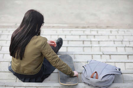 A young hipster girl is riding a skateboard. Girls girlfriends fの写真素材