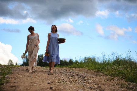 Two girls in dresses in summer fieldの写真素材