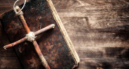 Religious old book on a wooden table. A religious cross tied witの写真素材