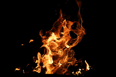 Tongues of flame of fire of orange-yellow color from burning fir