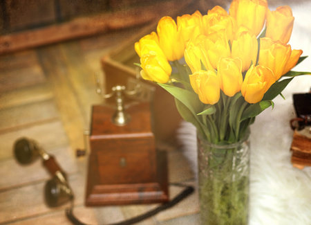 A bouquet of yellow tulips in a vase in the interior of a retroの写真素材