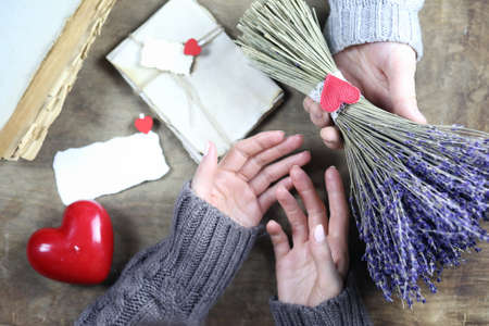 young man gives a girl a bouquet of lavender flowers on holidayの写真素材