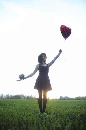 A girl in a hat on a walk in the park. A girl with a basket walkの写真素材