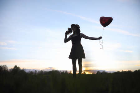 A girl in a hat on a walk in the park. A girl with a basket walkの写真素材