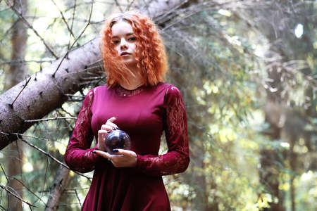 The red-haired witch holds a ritual with a crystal ballの写真素材