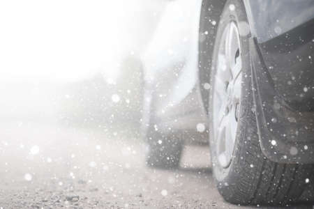 A car on a rural road in the first autumn snow. The first winterの写真素材